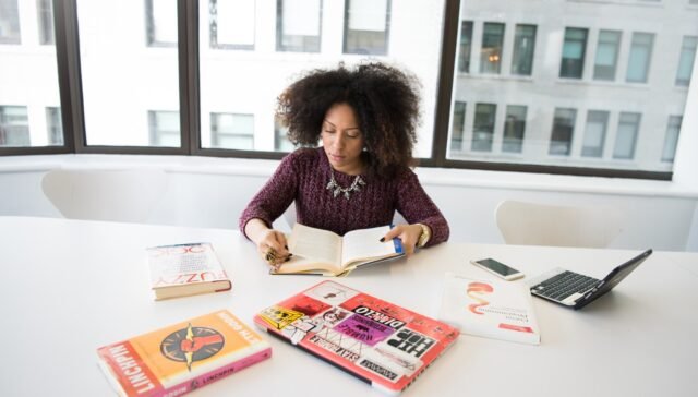 Woman Reading Book While Sitting